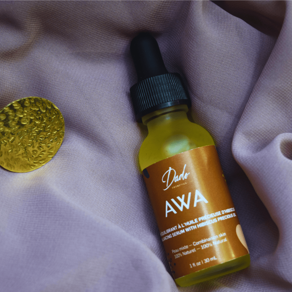 Sérum AWA de Dado Cosmetics sur tissu mauve avec médaillon doré, huile précieuse pour teint unifié