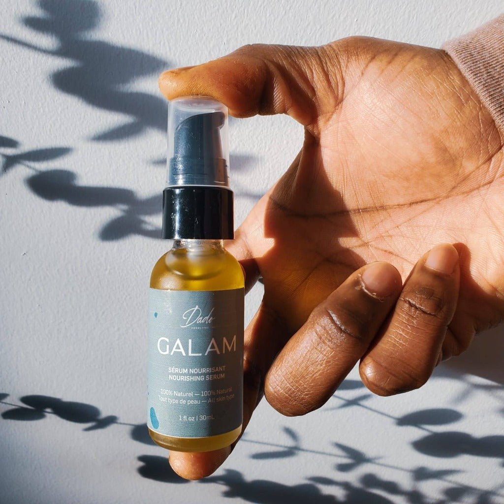 Homme noir tient le sérum visage pour homme dans un flacon en verre givrée de 30ml avec bouchon doseur noire - Dado Cosmetics